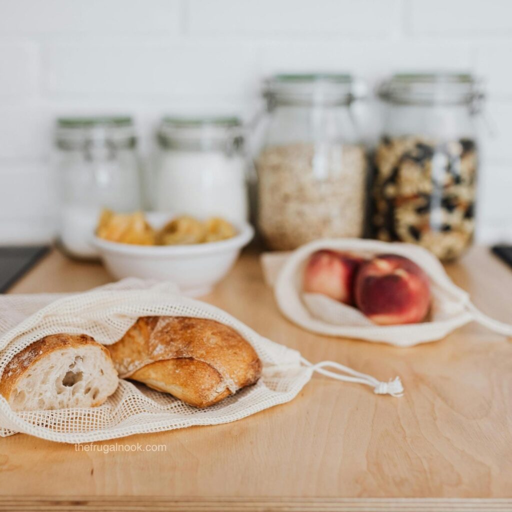 Homemade bread, peaches, and pantry jars styled on a wooden table for a frugal living blog post